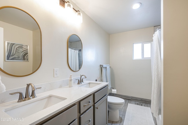 full bath featuring a sink, toilet, and double vanity