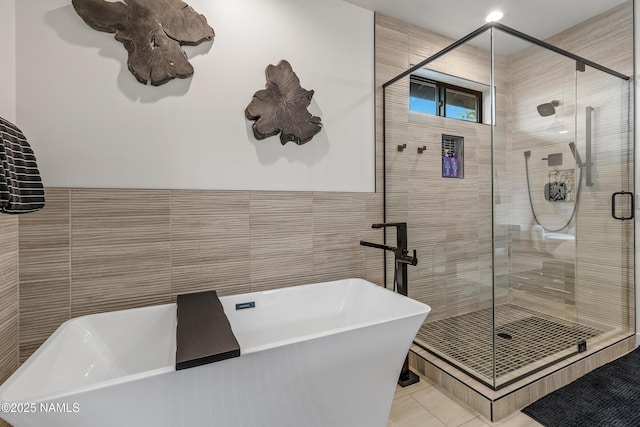2625 S Cottonrose Ln, Flagstaff, AZ 86005 - bathroom with tile walls, a shower stall, a freestanding tub, and tile patterned floors