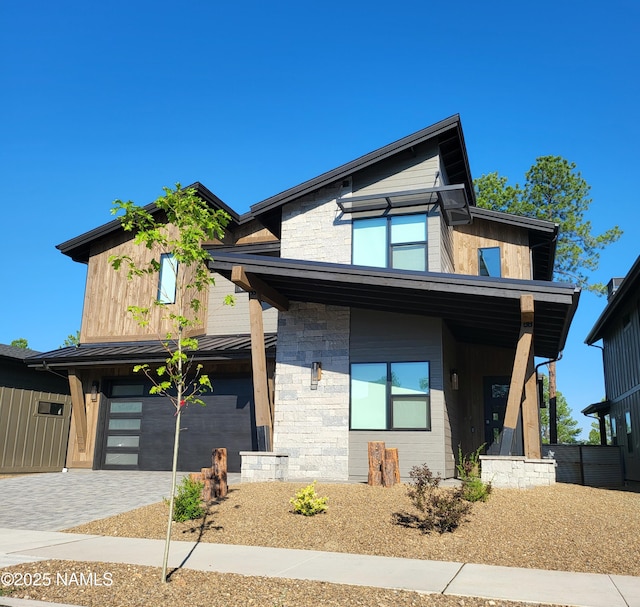 2625 S Cottonrose Ln, Flagstaff, AZ 86005 - contemporary house with an attached garage, driveway, and stone siding