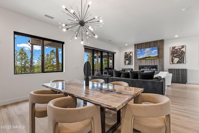 2625 S Cottonrose Ln, Flagstaff, AZ 86005 - dining area with a chandelier, light wood-type flooring, baseboards, recessed lighting, and a fireplace