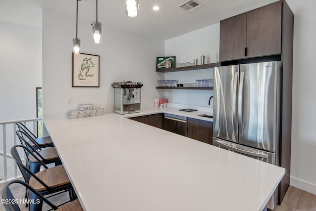 10299 E White Feather Ln, Scottsdale, AZ 85262 - kitchen featuring stainless steel appliances, a peninsula, a kitchen breakfast bar, light countertops, and recessed lighting