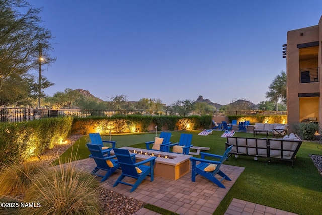 10299 E White Feather Ln, Scottsdale, AZ 85262 - patio terrace at dusk with an outdoor living space with a fire pit, a patio area, and a mountain view