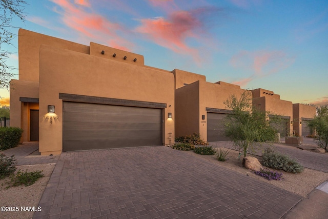 10299 E White Feather Ln, Scottsdale, AZ 85262 - adobe home with decorative driveway, stucco siding, and a garage