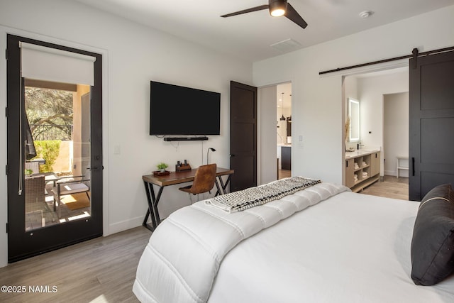 10299 E White Feather Ln, Scottsdale, AZ 85262 - bedroom featuring light wood-style floors, a barn door, ensuite bath, access to outside, and ceiling fan