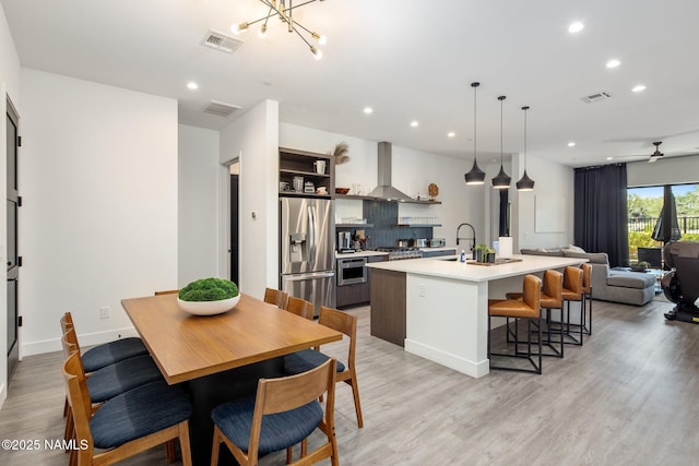 10299 E White Feather Ln, Scottsdale, AZ 85262 - kitchen with stainless steel appliances, range hood, recessed lighting, light wood-style flooring, and light countertops