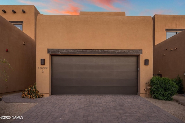 10299 E White Feather Ln, Scottsdale, AZ 85262 - pueblo-style house featuring stucco siding, a garage, and decorative driveway