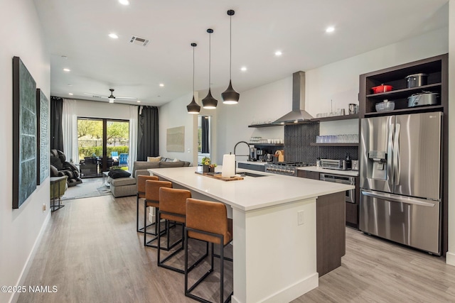 10299 E White Feather Ln, Scottsdale, AZ 85262 - kitchen featuring stainless steel appliances, wall chimney range hood, light wood finished floors, recessed lighting, and open shelves