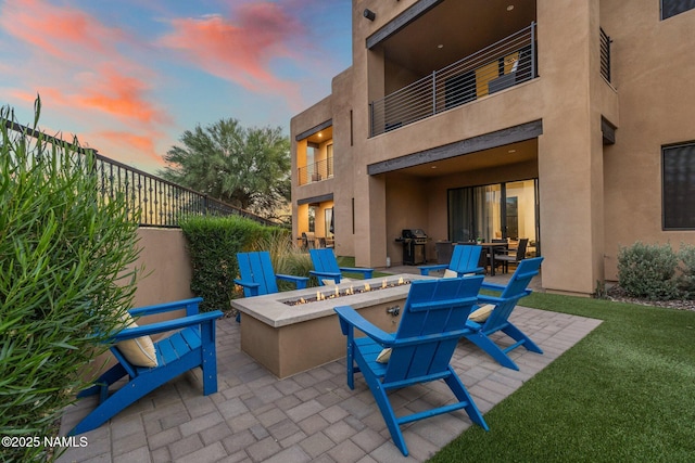 10299 E White Feather Ln, Scottsdale, AZ 85262 - patio terrace at dusk featuring an outdoor fire pit, a patio, a balcony, and area for grilling