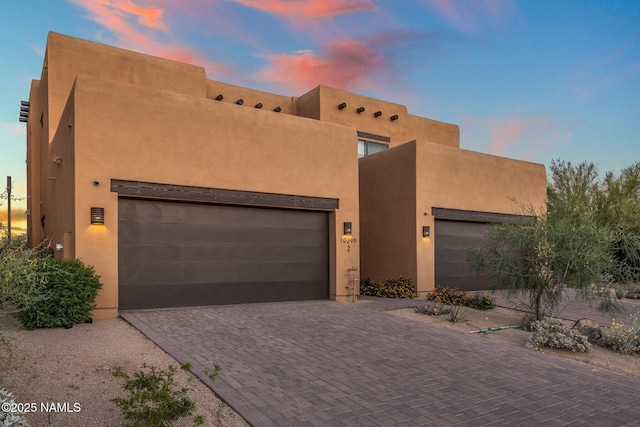10299 E White Feather Ln, Scottsdale, AZ 85262 - pueblo-style home featuring decorative driveway, stucco siding, and an attached garage