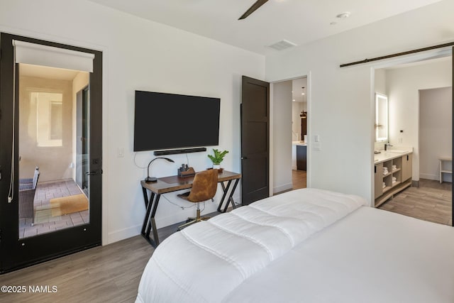10299 E White Feather Ln, Scottsdale, AZ 85262 - bedroom with light wood finished floors and ensuite bathroom
