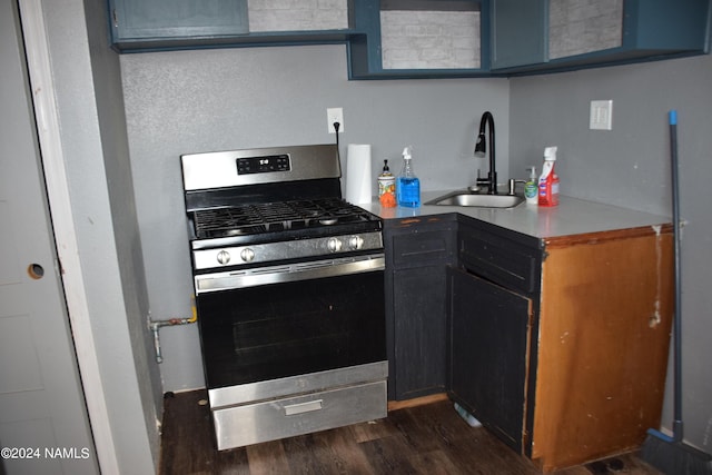 kitchen with stainless steel range with gas stovetop, dark hardwood / wood-style flooring, and sink