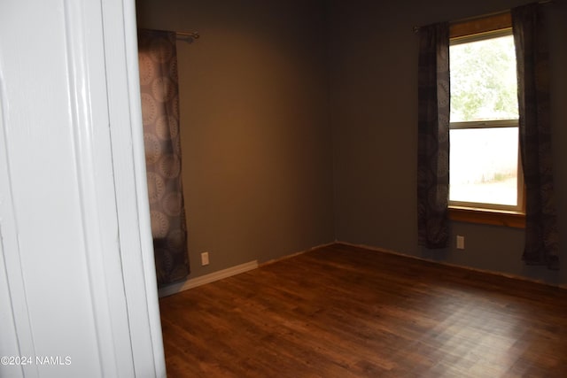 spare room with dark wood-type flooring