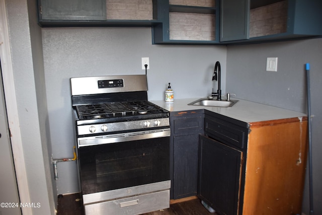 kitchen with stainless steel gas range oven, dark hardwood / wood-style floors, and sink