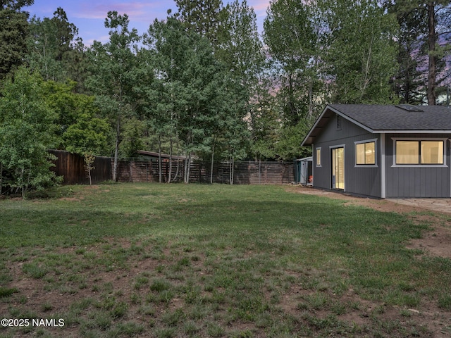 4375 Canyon Loop, Flagstaff, AZ 86005 - yard at dusk with a fenced backyard and view of wooded area