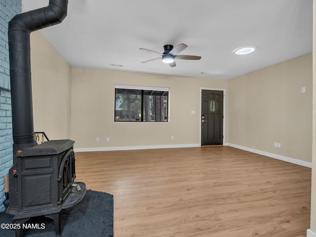 4375 Canyon Loop, Flagstaff, AZ 86005 - unfurnished living room with a wood stove, a ceiling fan, and light wood-style floors