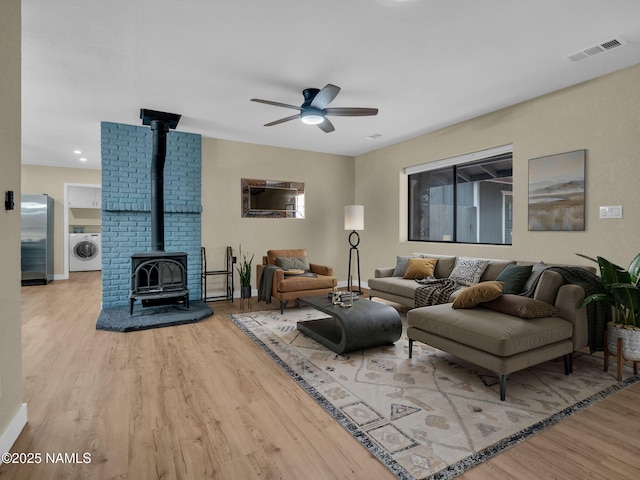 4375 Canyon Loop, Flagstaff, AZ 86005 - living area featuring a wood stove, washer / dryer, wood finished floors, and ceiling fan