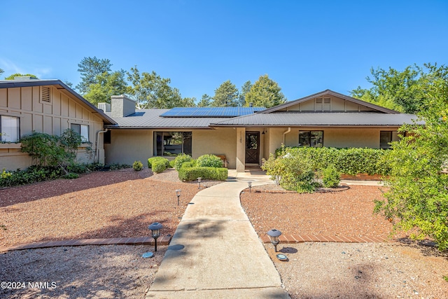 ranch-style home featuring solar panels