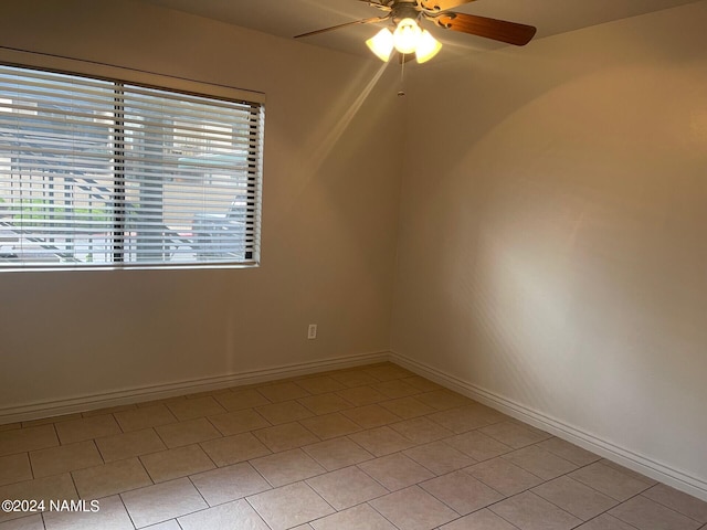 tiled spare room with ceiling fan