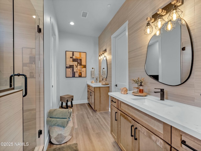 2566 S Cottonrose Ln, Flagstaff, AZ 86005 - full bathroom with two vanities, a stall shower, wood finished floors, and baseboards