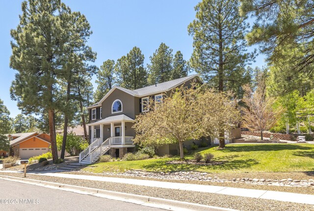 1085 N Conifer Rd, Flagstaff, AZ 86001 - view of front of property featuring a garage, a front lawn, and a porch