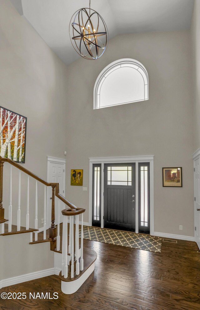 1085 N Conifer Rd, Flagstaff, AZ 86001 - foyer entrance featuring wood finished floors, high vaulted ceiling, stairway, a chandelier, and baseboards