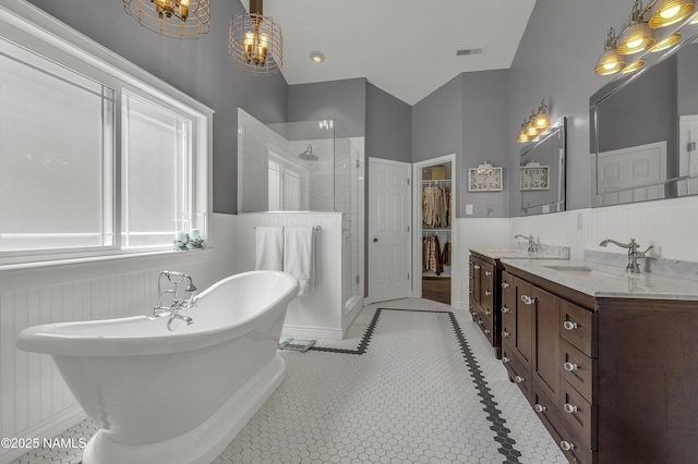1085 N Conifer Rd, Flagstaff, AZ 86001 - bathroom featuring a shower stall, double vanity, a freestanding tub, and wainscoting