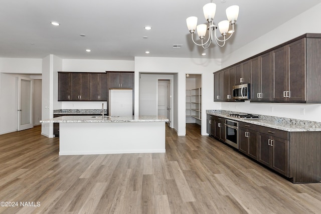 kitchen with sink, dark brown cabinetry, appliances with stainless steel finishes, and decorative light fixtures