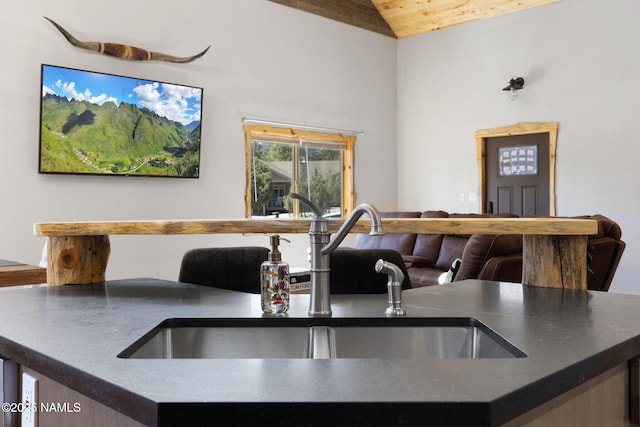 kitchen featuring a sink, wood ceiling, vaulted ceiling, and dark countertops