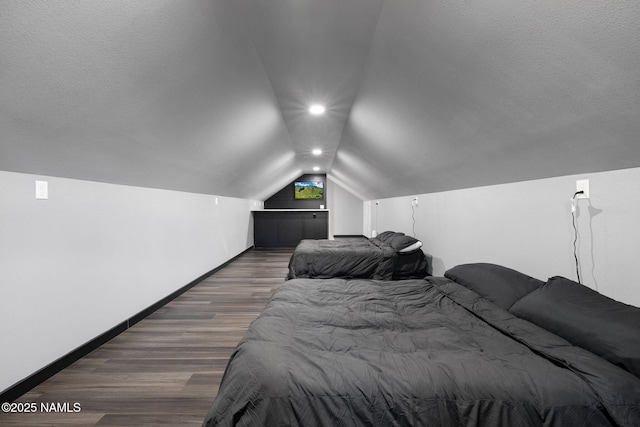 bedroom featuring baseboards, vaulted ceiling, and wood finished floors