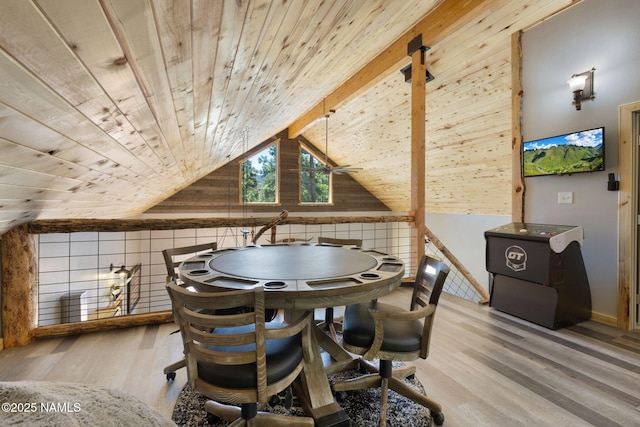 dining space featuring vaulted ceiling, wood finished floors, wooden ceiling, baseboards, and wooden walls