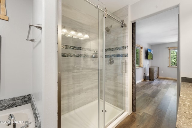 full bath featuring baseboards, a shower stall, and wood finished floors