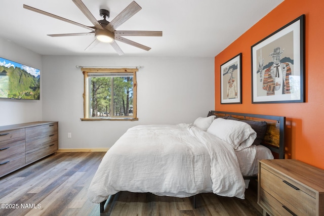 bedroom featuring baseboards, ceiling fan, and wood finished floors