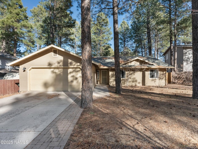 view of front of house featuring driveway, a garage, and fence