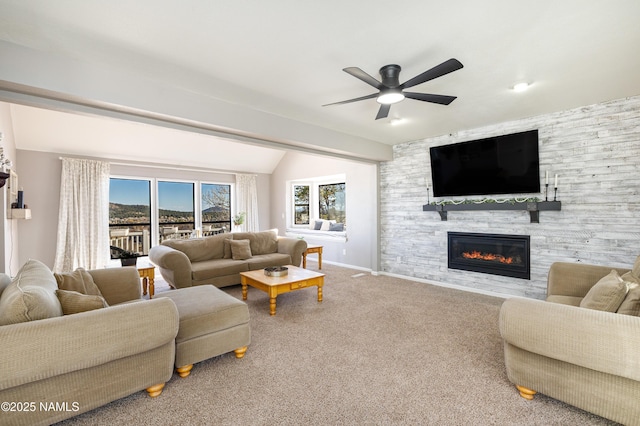 living area with lofted ceiling, a large fireplace, carpet flooring, baseboards, and ceiling fan