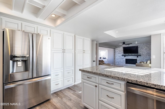 5495 E Crisp Hill Rd, Flagstaff, AZ 86004 - kitchen featuring stainless steel appliances, light wood-style flooring, a fireplace, and white cabinetry