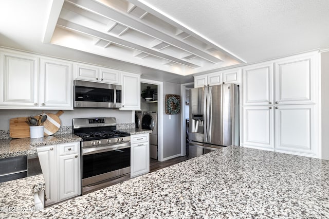 5495 E Crisp Hill Rd, Flagstaff, AZ 86004 - kitchen with white cabinetry, separate washer and dryer, light stone countertops, and appliances with stainless steel finishes