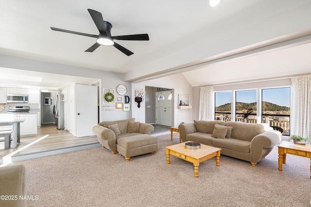 living room featuring ceiling fan and vaulted ceiling