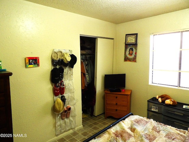 bedroom featuring a textured ceiling, multiple windows, and a closet