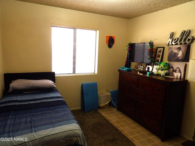 bedroom featuring a textured ceiling and light colored carpet