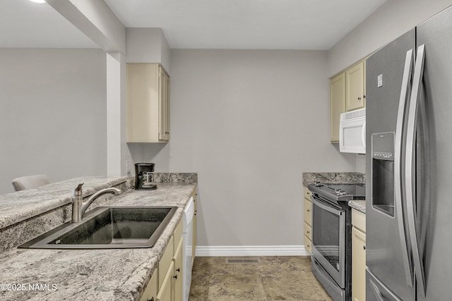 2800 N Saddleback Way Unit 2, Flagstaff, AZ 86004 - kitchen with cream cabinetry, stainless steel appliances, visible vents, a sink, and baseboards