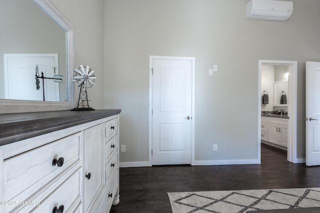 interior space featuring wood-type flooring, a wall mounted air conditioner, and vanity