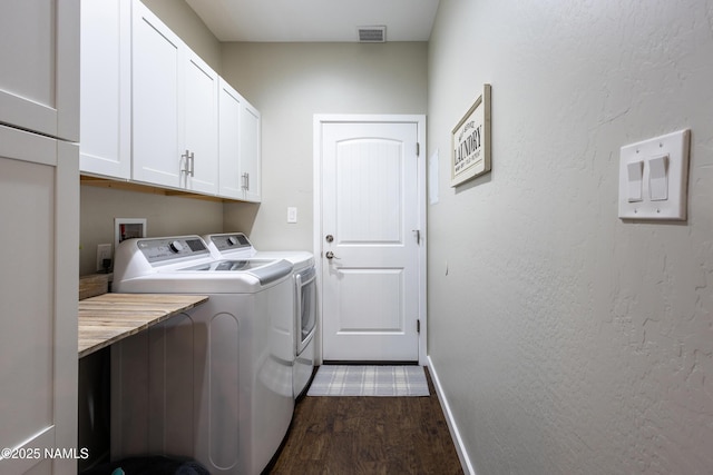 laundry room with dark hardwood / wood-style flooring, cabinets, and independent washer and dryer