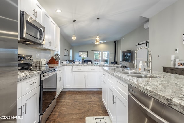 kitchen featuring sink, white cabinets, stainless steel appliances, and a barn door