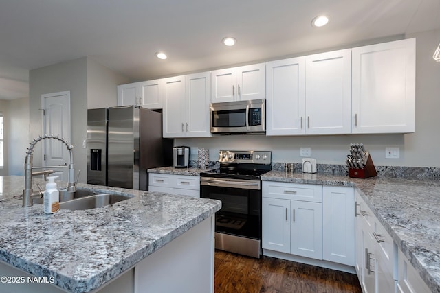 kitchen featuring white cabinets, appliances with stainless steel finishes, dark wood-type flooring, sink, and a kitchen island with sink