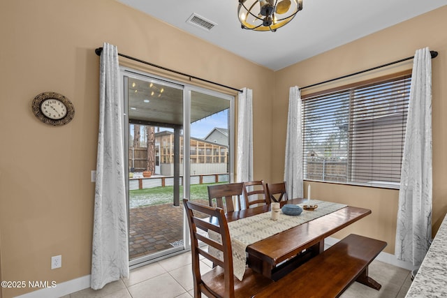 dining room featuring visible vents, a notable chandelier, baseboards, and light tile patterned floors