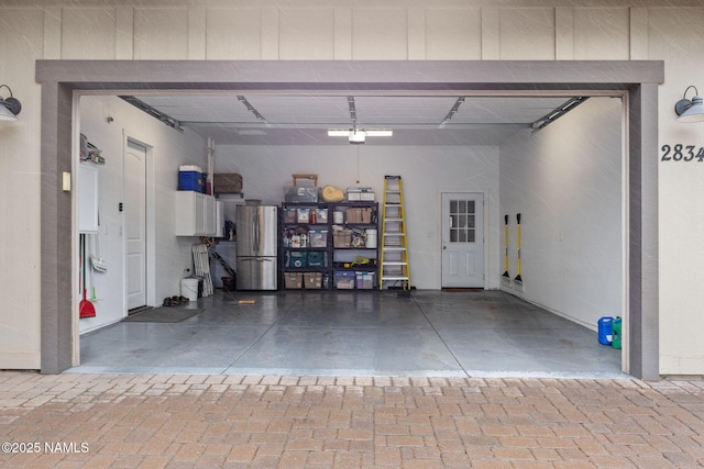 garage featuring freestanding refrigerator and a garage door opener