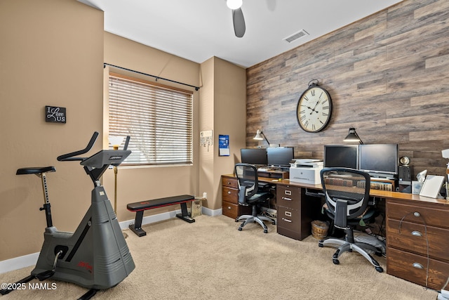 office area featuring carpet floors, wood walls, baseboards, and visible vents