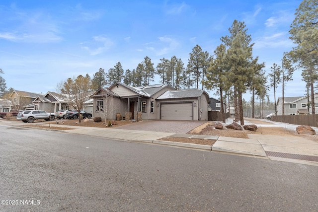 view of front of home with a garage, a residential view, driveway, and fence