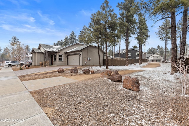 view of home's exterior featuring fence, driveway, and an attached garage