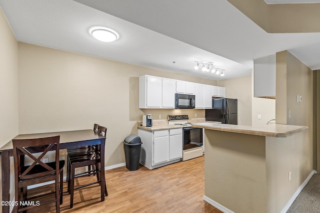 1385 W University Ave Unit 194, Flagstaff, AZ 86001 - kitchen with black appliances, light countertops, a peninsula, and white cabinets